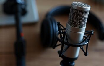 Configuração de microfone profissional para podcast, representando o prêmio de consultoria para podcast.